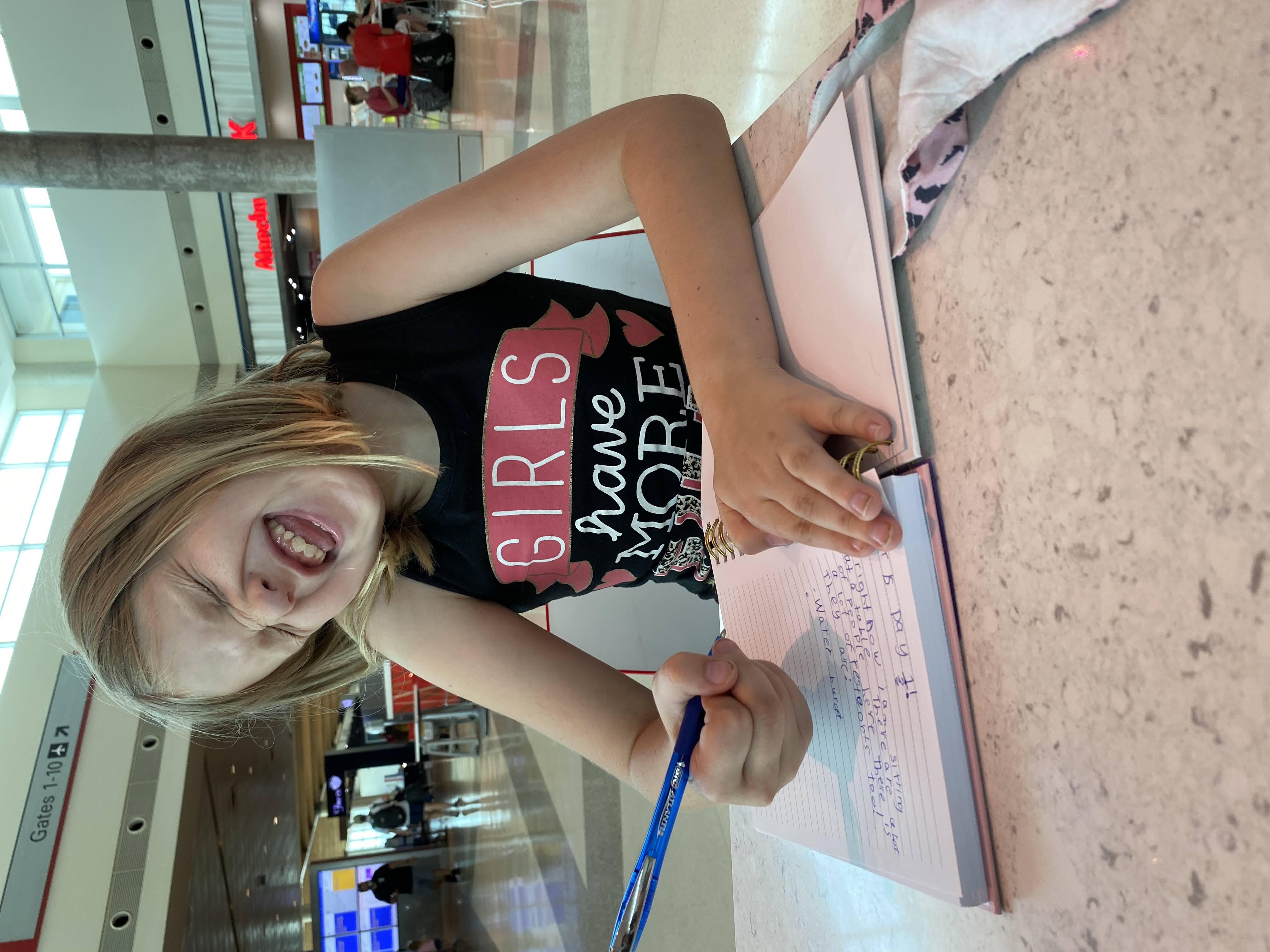 A girl at the airport writing in her diary about our family trip to Oregon